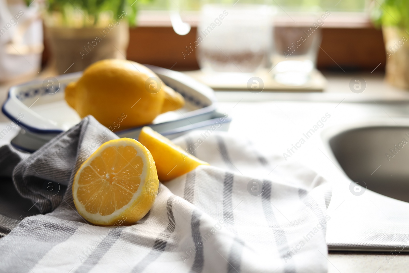 Photo of Fresh ripe lemons on countertop in kitchen, closeup. Space for text