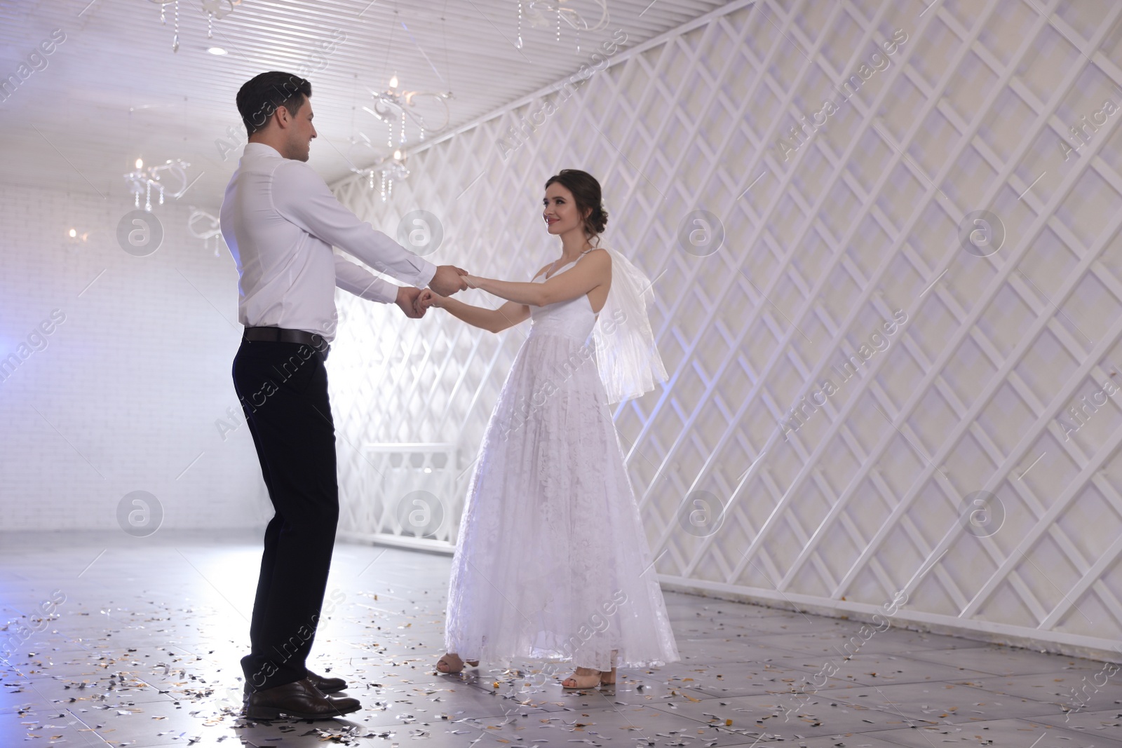 Photo of Happy newlywed couple dancing together in festive hall