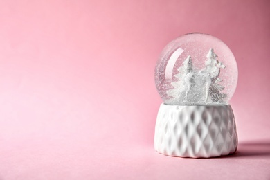 Photo of Snow globe with deer and trees on color background. Space for text