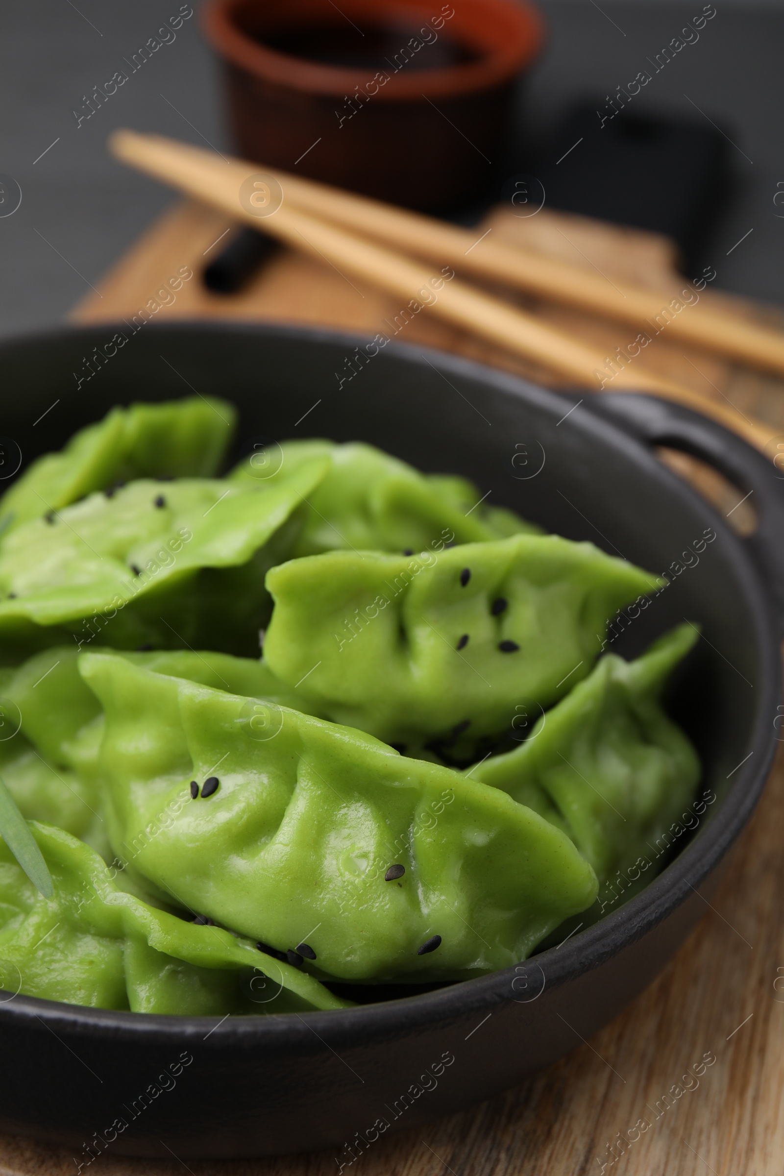 Photo of Delicious green dumplings (gyozas) on wooden table, closeup