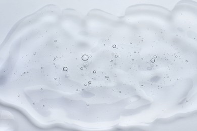 Photo of Sample of cosmetic oil on white background, closeup