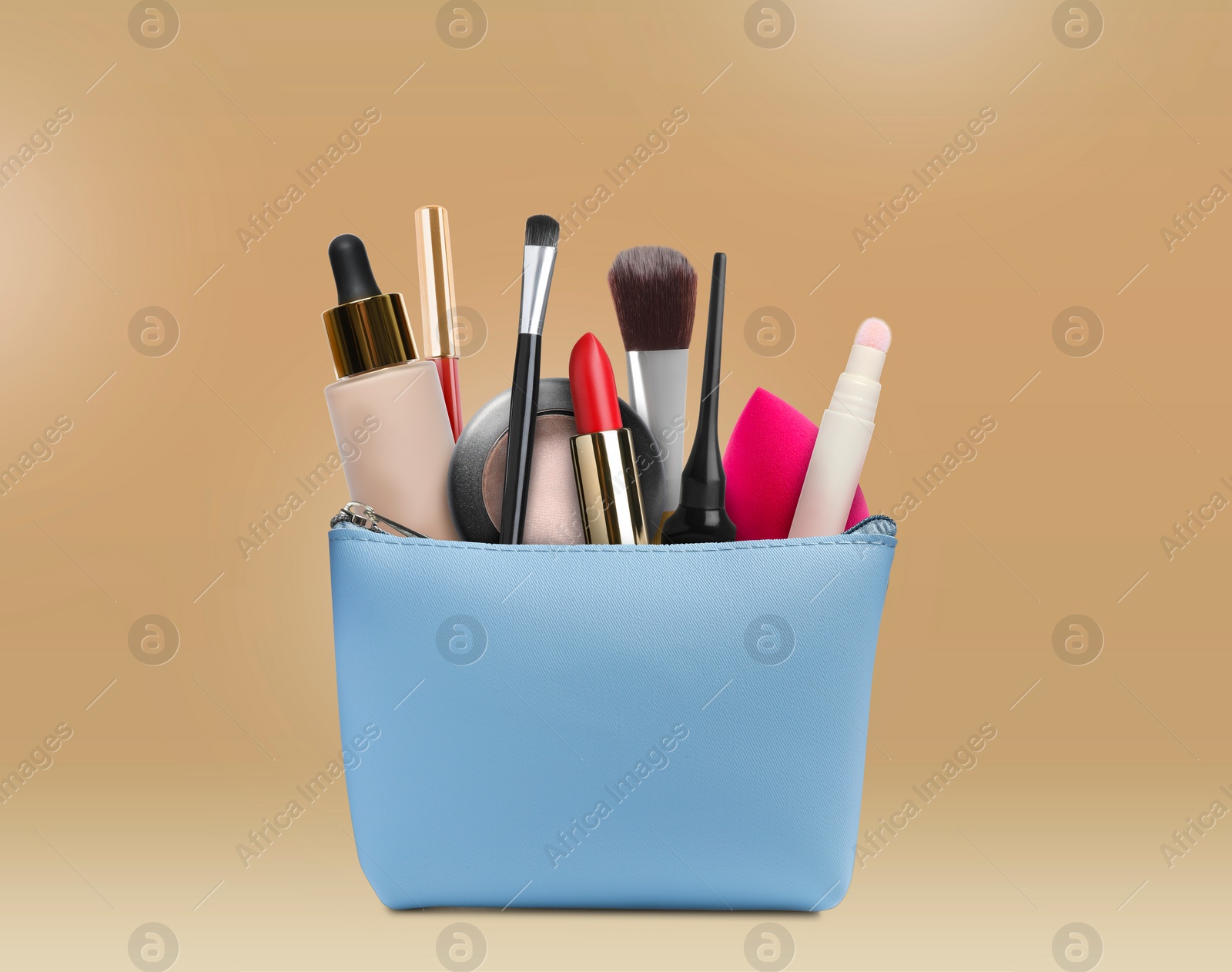 Image of Cosmetic bag filled with makeup products on beige background