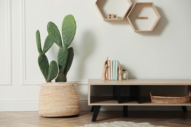 Stylish room interior with beautiful potted cactus and wooden table