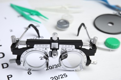 Photo of Trial frame with different ophthalmologist tools on white background, closeup