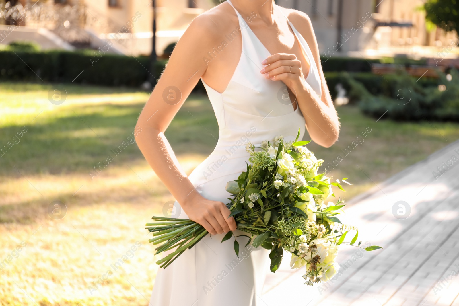 Photo of Bride in beautiful wedding dress with bouquet outdoors, closeup