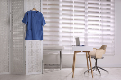 Photo of Doctor's office interior with desk and examination couch