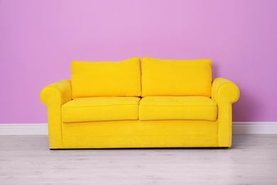 Photo of Room interior with comfortable sofa near color wall