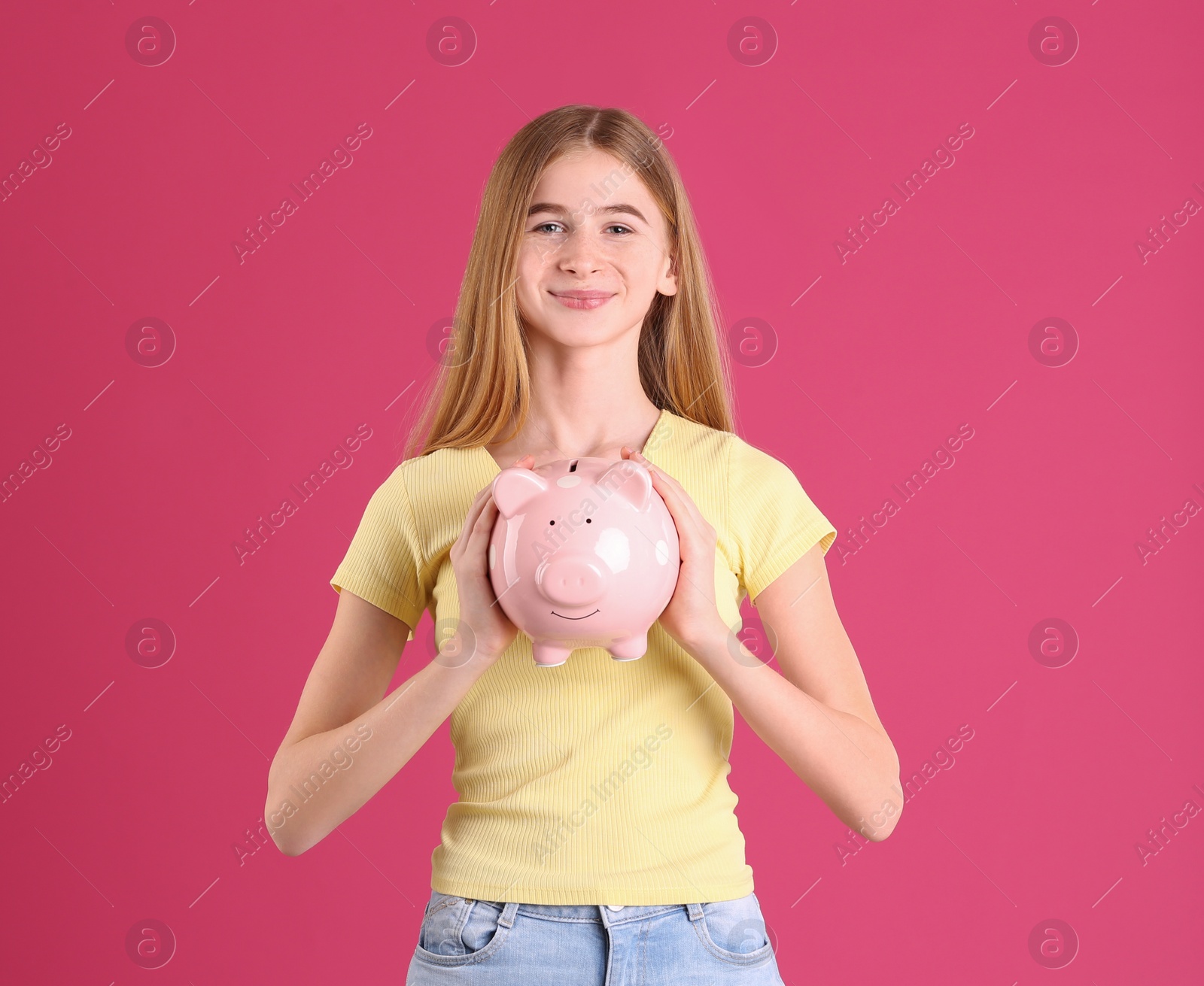 Photo of Teen girl with piggy bank on color background