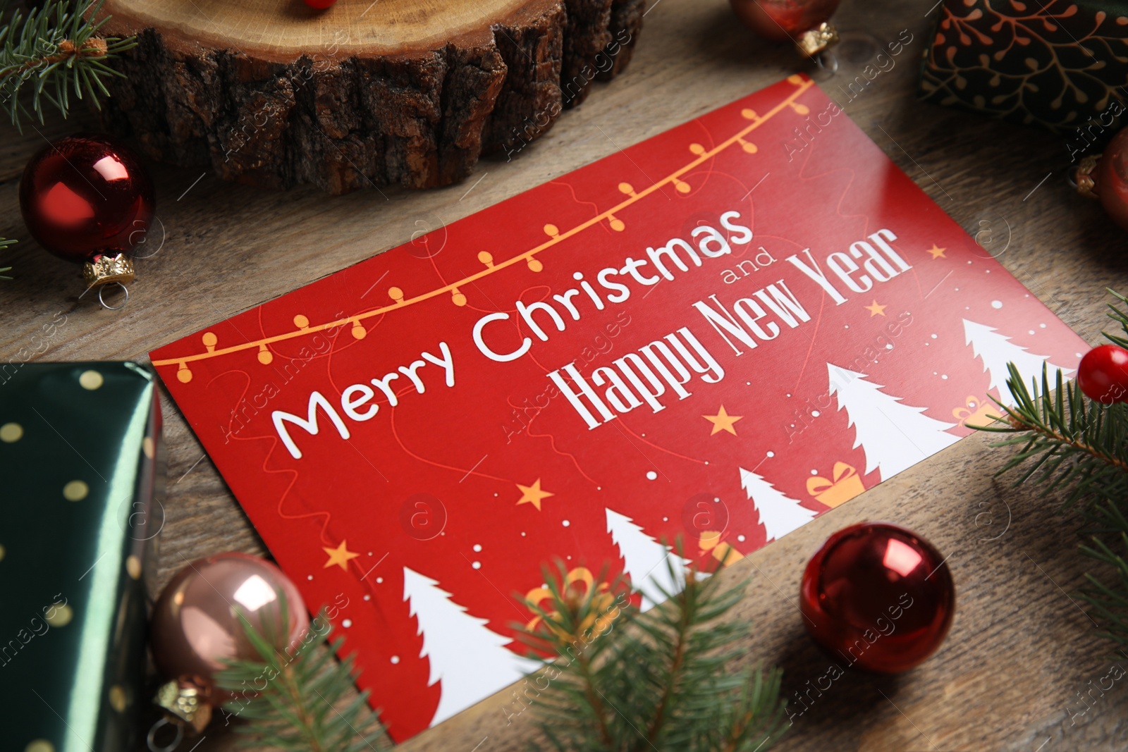 Photo of Greeting card and Christmas decor on wooden background, closeup