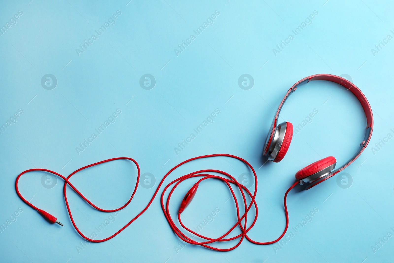 Photo of Stylish headphones on color background, top view. Space for text