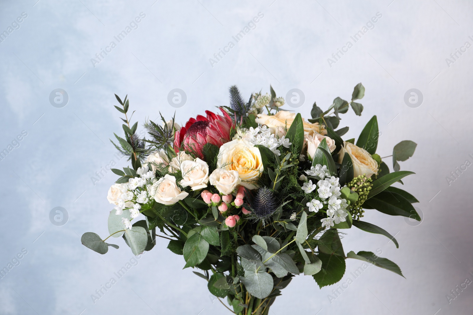 Photo of Beautiful bouquet with roses on light blue background