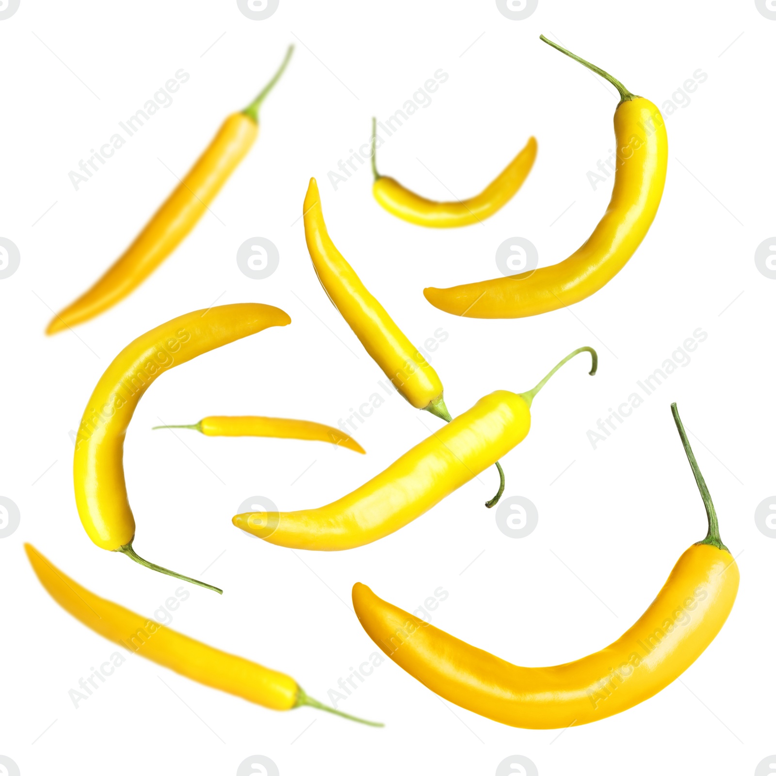 Image of Ripe yellow chili peppers flying on white background 