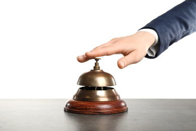 Photo of Woman ringing hotel service bell at grey stone table