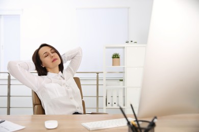 Woman relaxing in office chair at workplace