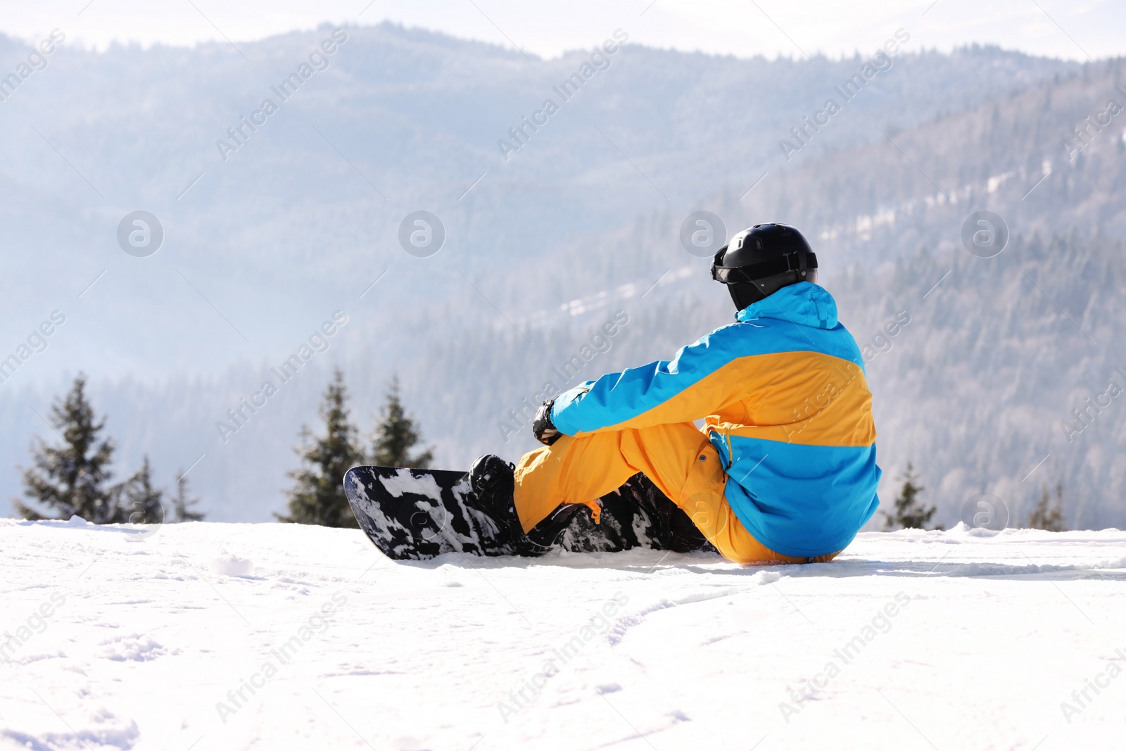 Photo of Man with snowboard resting in mountains. Winter vacation