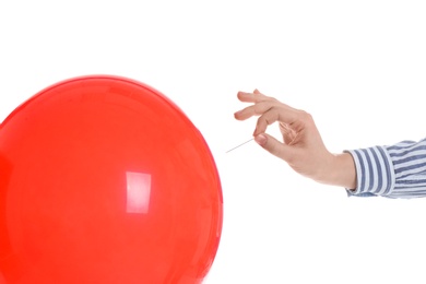 Woman piercing red balloon on white background, closeup