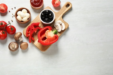Flat lay composition with fresh pizza  ingredients on white wooden table. Space for text