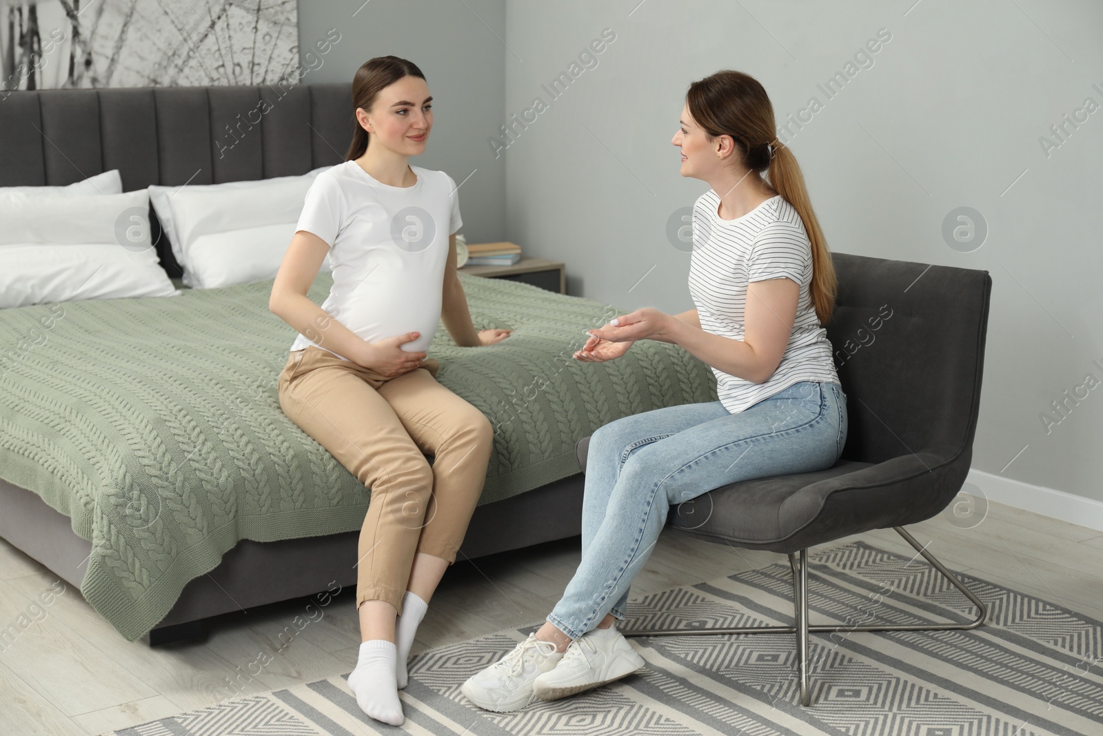 Photo of Doula working with pregnant woman in bedroom. Preparation for child birth