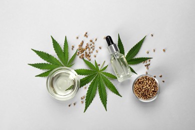 Photo of Flat lay composition with CBD oil or THC tincture and hemp leaves on light background