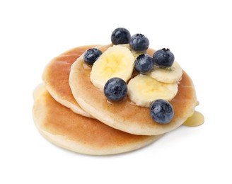 Photo of Delicious pancakes with banana slices, blueberries and honey isolated on white