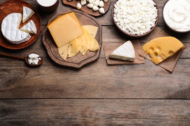Photo of Flat lay composition with dairy products on wooden table. Space for text
