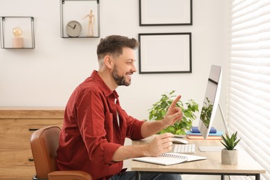 Photo of Man studying on computer at home. Online translation course