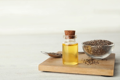 Composition with chia seeds and oil on wooden table. Space for text