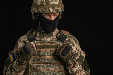 Soldier in Ukrainian military uniform on black background