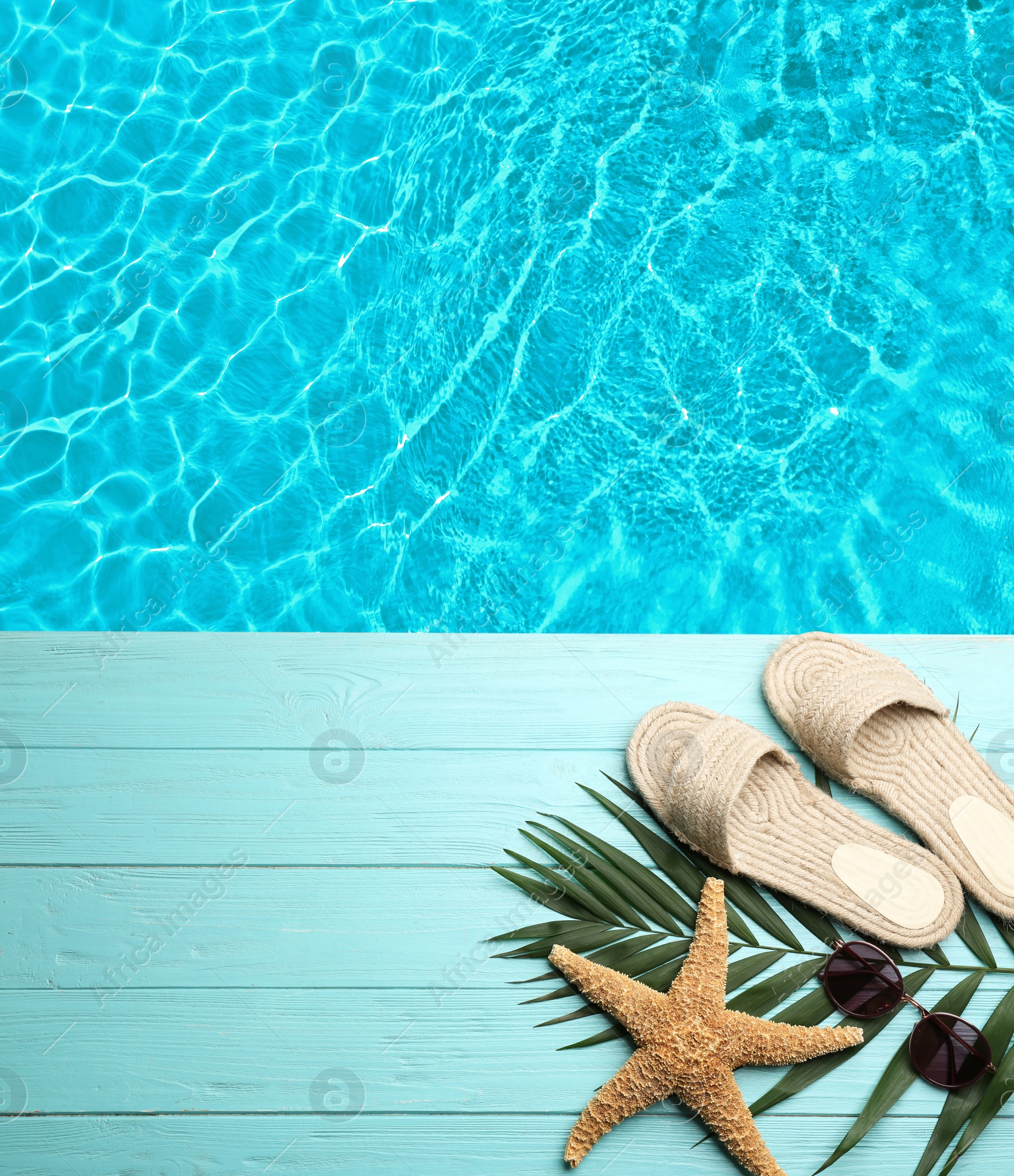 Image of Beach accessories on turquoise wooden deck near swimming pool, flat lay. Space for text 