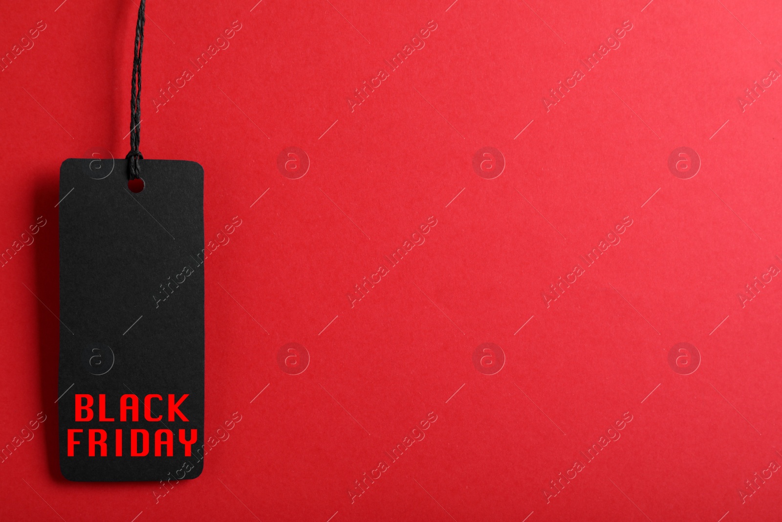 Image of Tag with phrase BLACK FRIDAY on red background, top view. Space for text