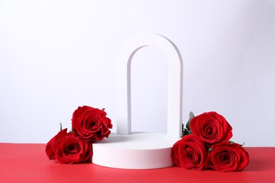 Stylish presentation for product. Geometric figures and roses on red table against white background