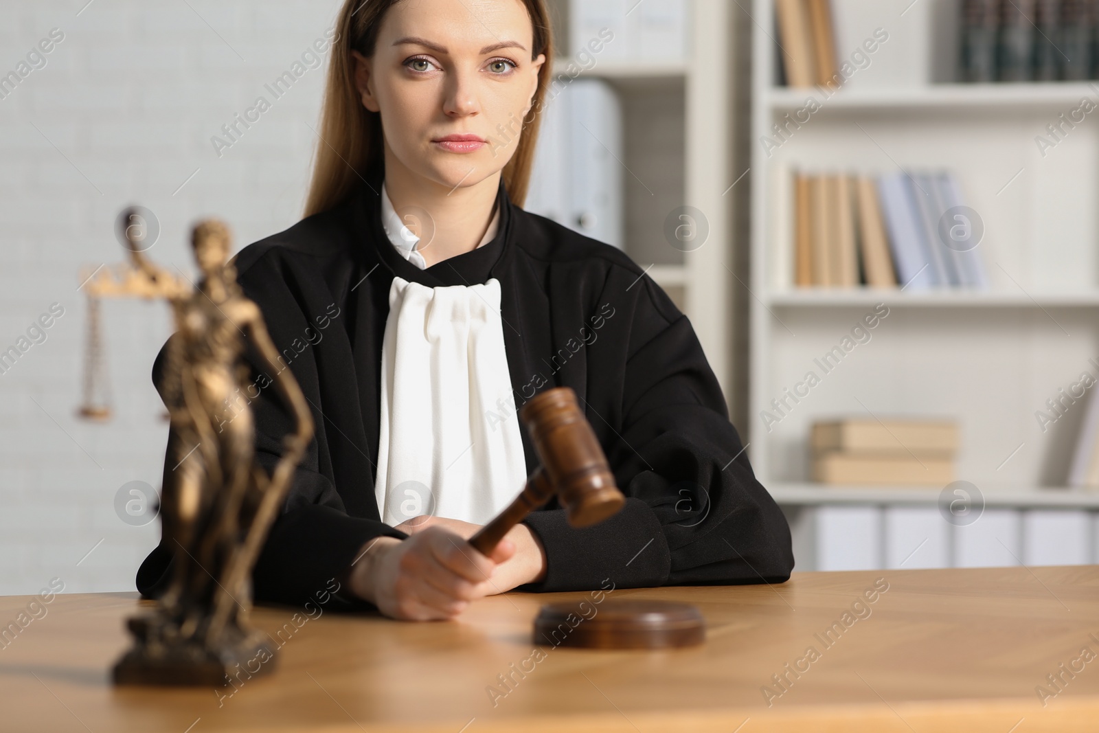 Photo of Judge striking mallet at wooden table indoors, selective focus. Space for text