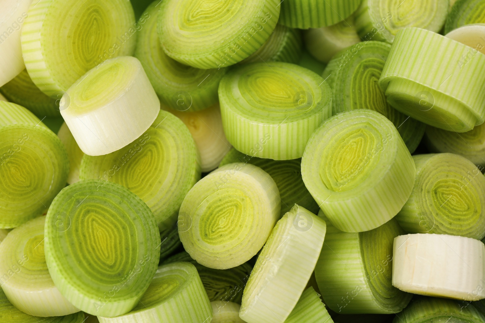 Photo of Fresh raw leek slices as background, above view
