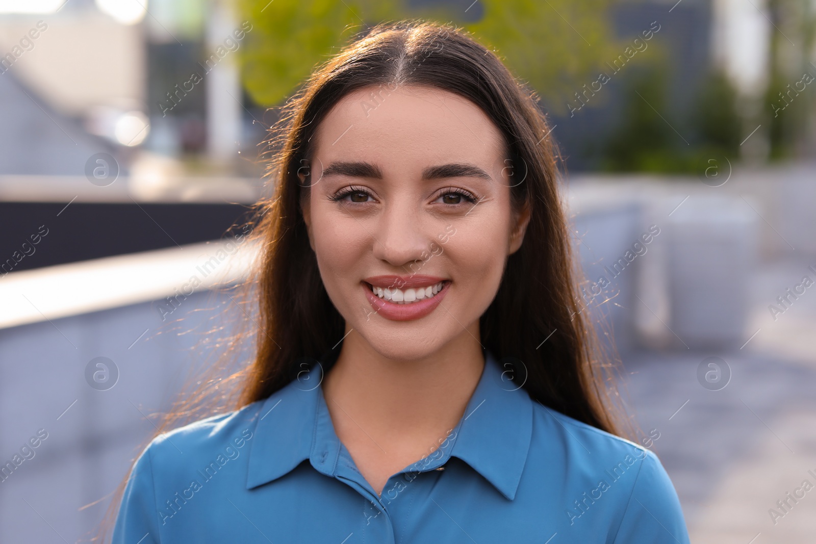 Photo of Portrait of beautiful woman outdoors. Attractive lady smiling and looking into camera