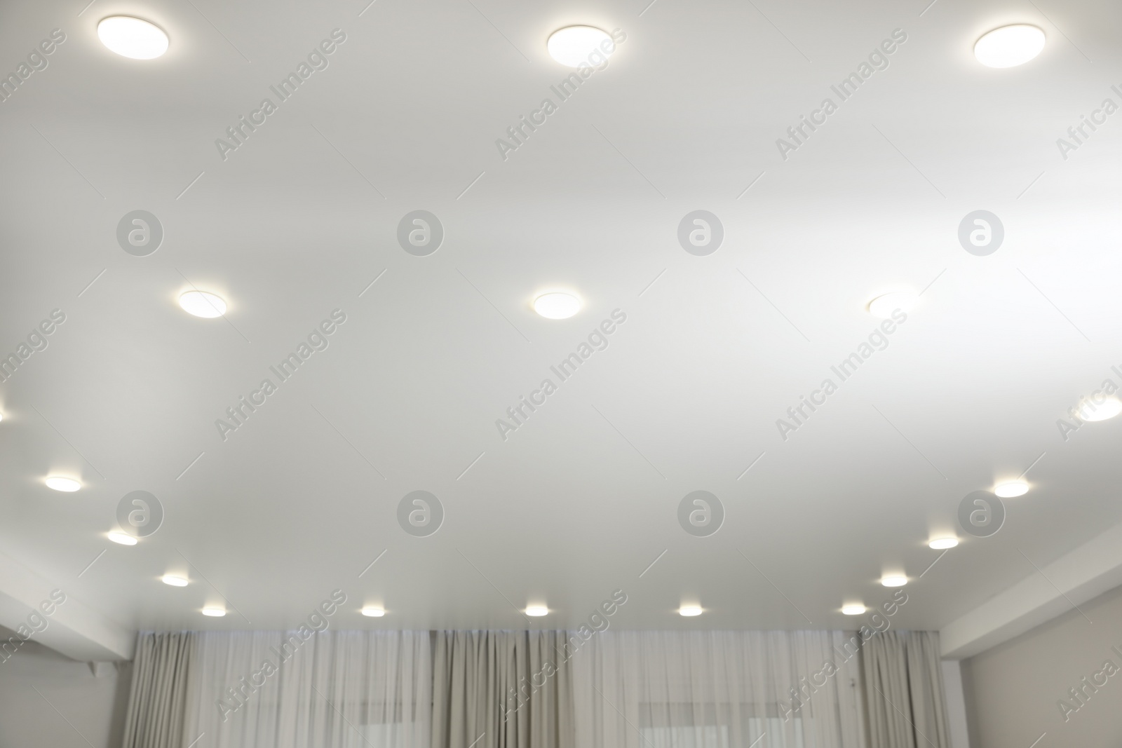 Photo of White ceiling with lamps indoors, below view