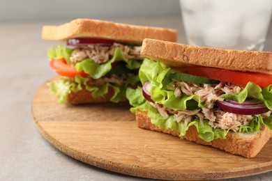 Photo of Delicious sandwiches with tuna and vegetables on light grey table, closeup. Space for text