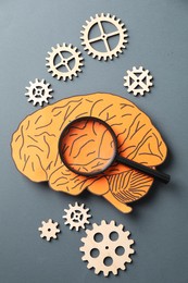 Amnesia. Paper cutout of human brain, cogwheels and magnifying glass on grey background, flat lay