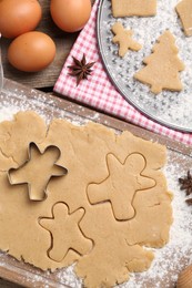 Making Christmas cookies. Flat lay composition with ingredients and raw dough on wooden table