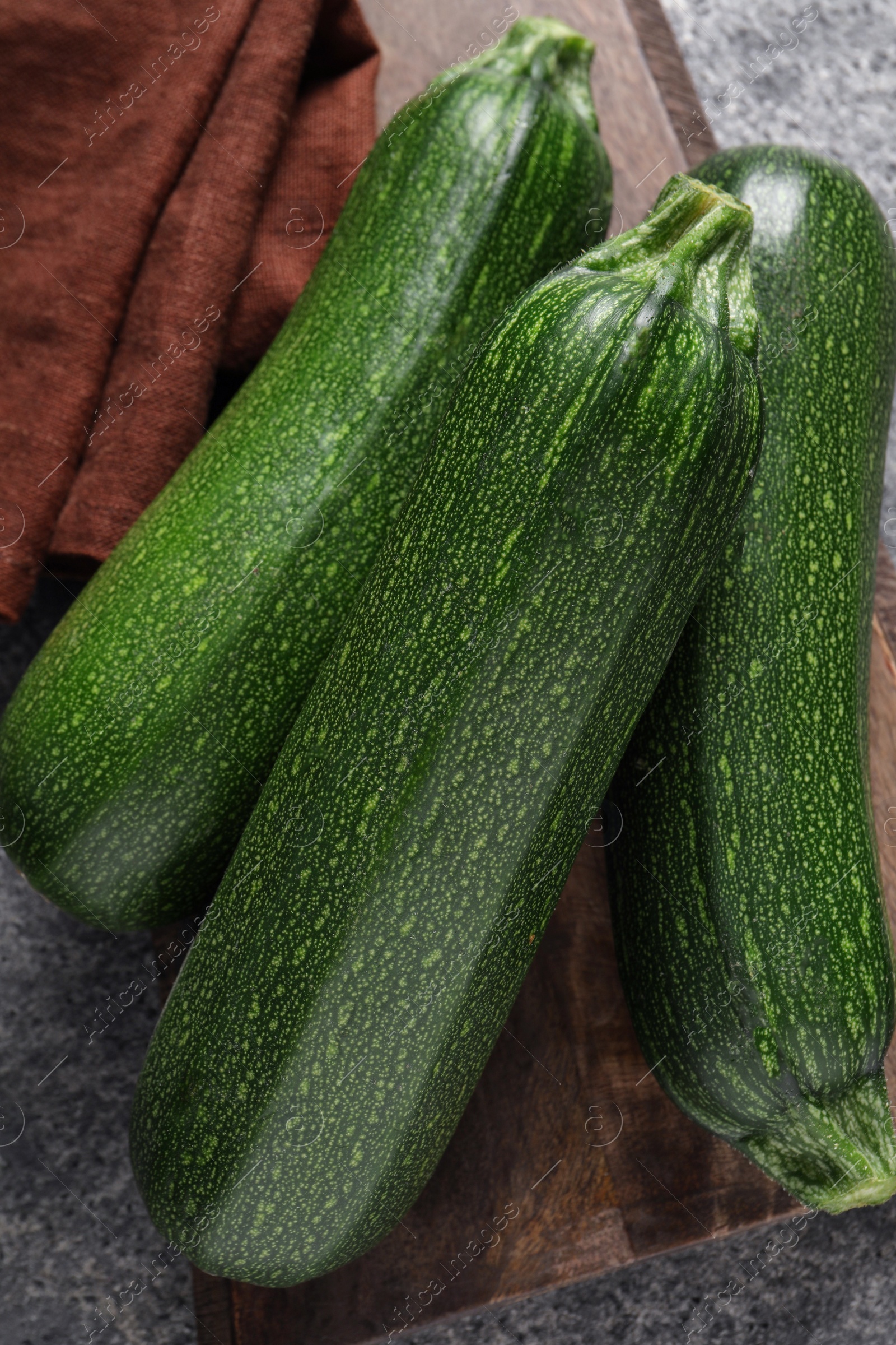 Photo of Raw ripe zucchinis on grey table, top view