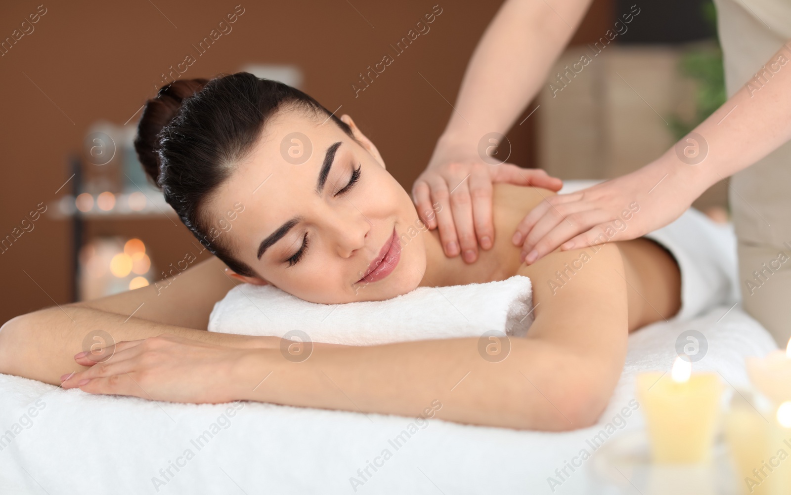 Photo of Young woman receiving massage in spa salon