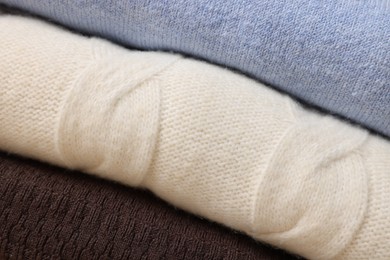 Photo of Closeup view of different warm folded sweaters as background