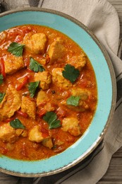 Delicious chicken curry on wooden table, top view