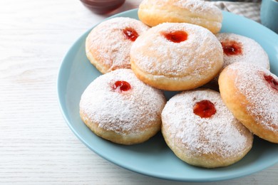 Delicious donuts with jam and powdered sugar on white table, closeup