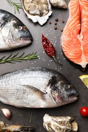 Photo of Flat lay composition with fresh raw dorado fish and different seafood on grey table