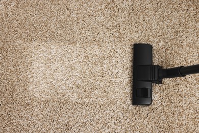 Hoovering carpet with vacuum cleaner, top view. Space for text