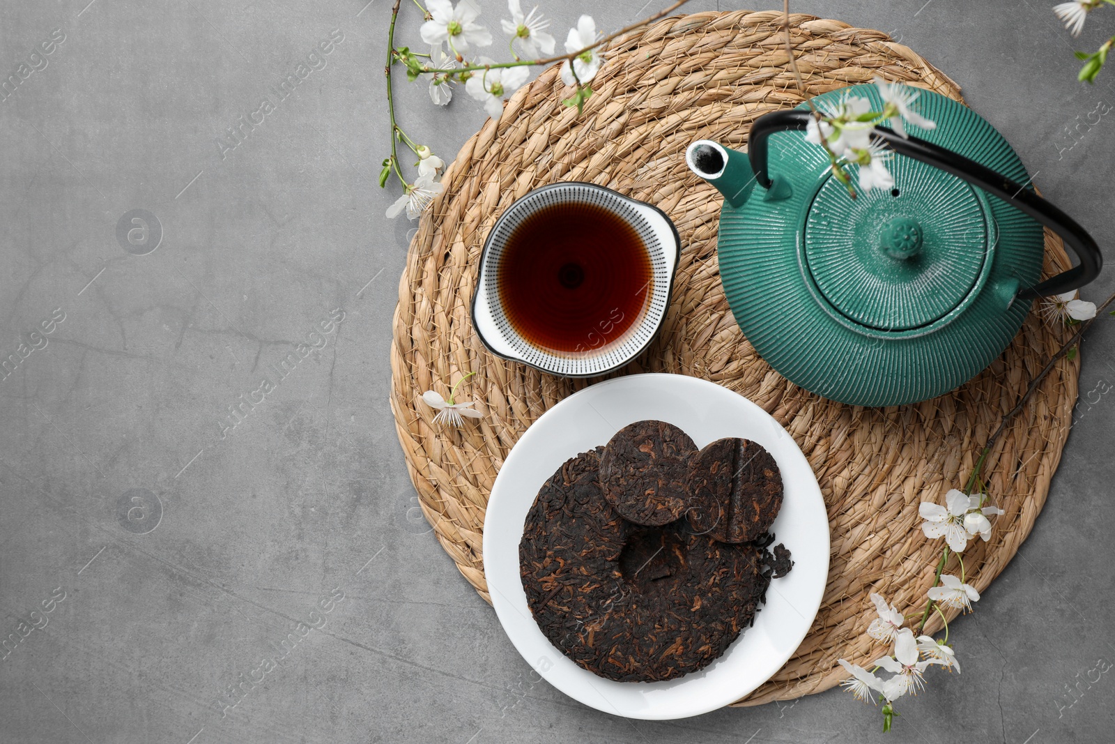 Photo of Flat lay composition with aromatic pu-erh tea on grey table. Space for text