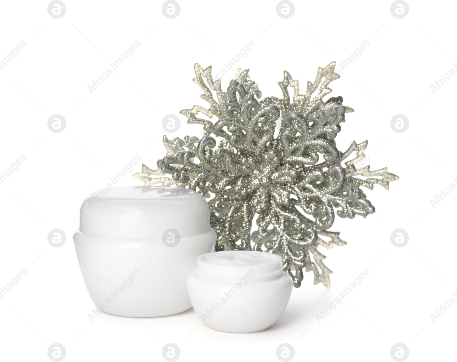 Photo of Jars of cream and snowflake on white background. Winter skin care