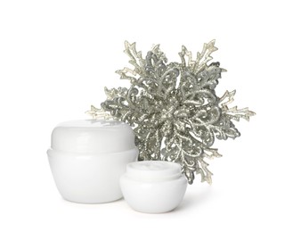 Photo of Jars of cream and snowflake on white background. Winter skin care