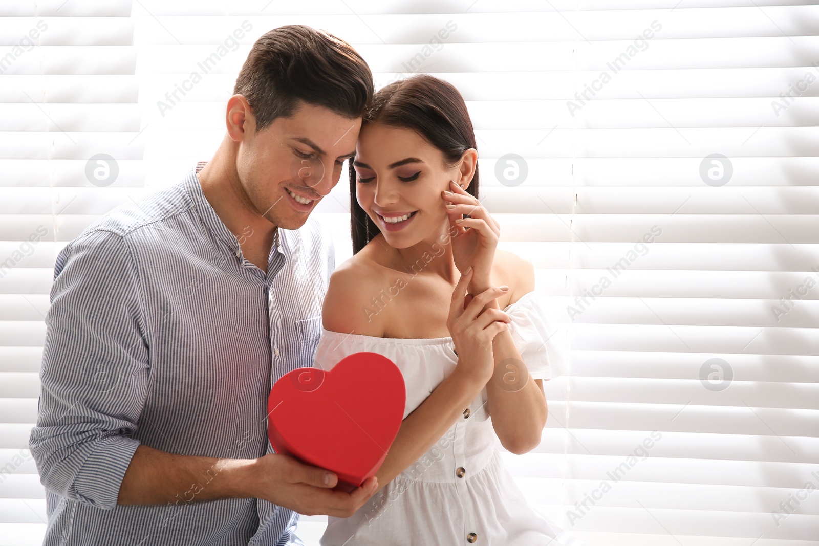 Photo of Lovely couple with gift box at home. Valentine's day celebration