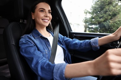 Woman with seatbelt holding steering wheel while driving her car